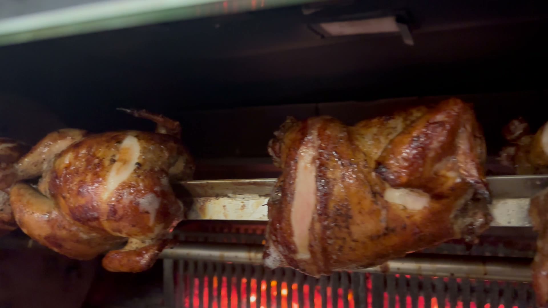 Pollos a la brasa en el asador, sobre brasas rojas, en Inka Brasas, Spring TX